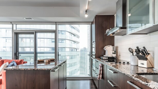 Cozinha moderna com vista para a paisagem urbana através de amplas janelas.