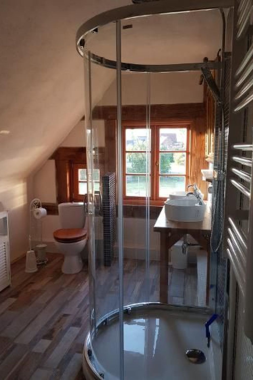 A bathroom with a glass-enclosed shower, a toilet, and a sink.