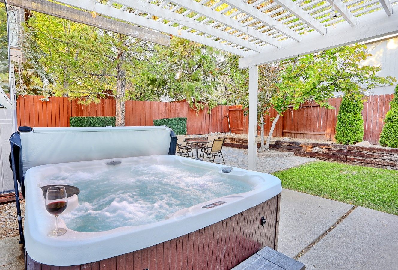 Un bain à remous où l’on peut se détendre en sirotant un verre de vin, le tout entouré d’une terrasse en bois et d’une clôture en bois.