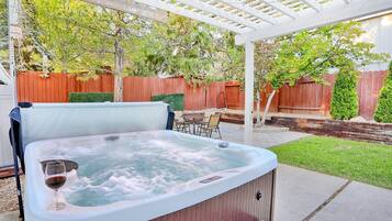 Un bain à remous où l’on peut se détendre en sirotant un verre de vin, le tout entouré d’une terrasse en bois et d’une clôture en bois.