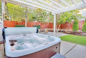 Un bain à remous où l’on peut se détendre en sirotant un verre de vin, le tout entouré d’une terrasse en bois et d’une clôture en bois.
