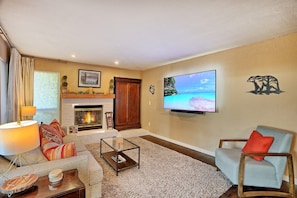 A living room with a fireplace, a television, and a sofa.