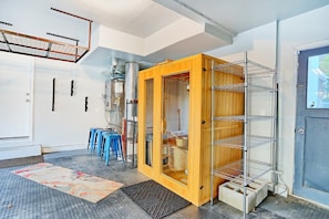 Une pièce avec un meuble en bois, des étagères en métal et une porte dotée d’une fenêtre.
