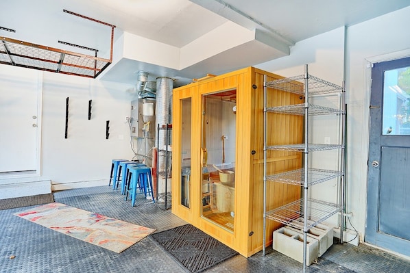 A room with a wooden cabinet, metal shelving, and a door with a window.