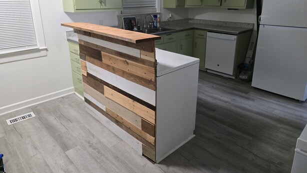 A kitchen with light green cabinets, a wooden countertop, and a white refrigerator. - Serene vintage 3b/2ba  home with AC. Medical professions MD, NP, RN are welcome. (Valdosta)