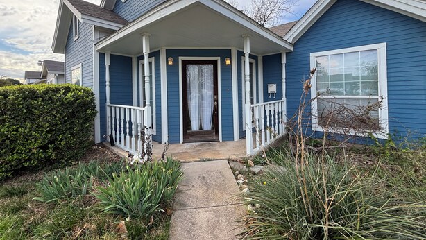 A blue house with a porch, a front door, and a mailbox. - Blue Cottage with a garden tub. Walking distance to TCU. Near the Zoo & Dickies (Fort Worth)