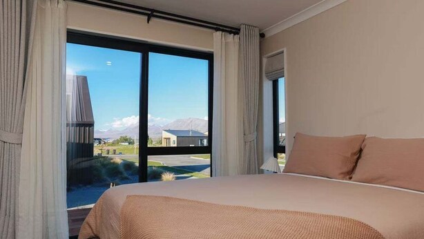 Ein Schlafzimmer mit einem großen Bett, Bergblick und einem Balkon.