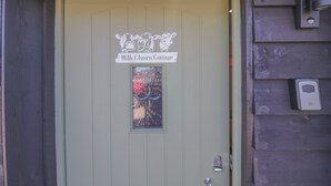 Eine Tür mit einem Schild, auf dem 'Milk Churn Cottage' steht.
