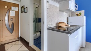 Une cuisine moderne équipée d’un four encastré, d’un réfrigérateur et d’un plan de travail sur lequel se trouve une miche de pain.