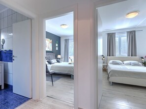 Een moderne hotelkamer met een groot bed, nachtkastjes, een bureau en uitzicht op de stad.