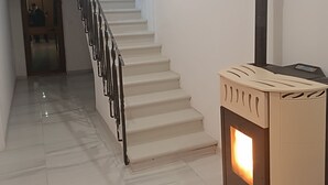 A staircase with a modern design, a wood-burning stove, and a door leading to another room. - MTB b&b (Alfonsine)