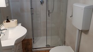 A bathroom with a glass-enclosed shower, a white sink, a toilet, and a bidet. - MTB b&b (Alfonsine)