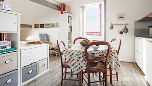 A compact, well-lit room with a dining table, chairs, and a bookshelf. - Barasteguia by Interhome (Saint-Jean-de-Luz)