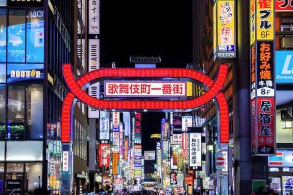 A brightly lit urban street with illuminated signs and storefronts. - Honmachi 5-chome (Tokyo)