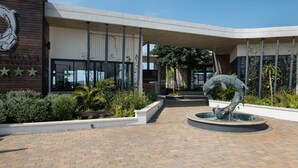 A building with a modern architectural style, a landscaped courtyard, and a central water feature. - Ballito Hills 887 (Ballito)