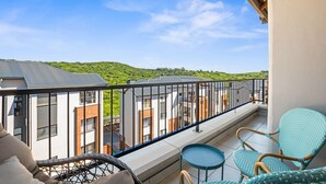 A balcony with wicker furniture, a view of buildings, and a clear sky. - Ballito Hills 887 (Ballito)