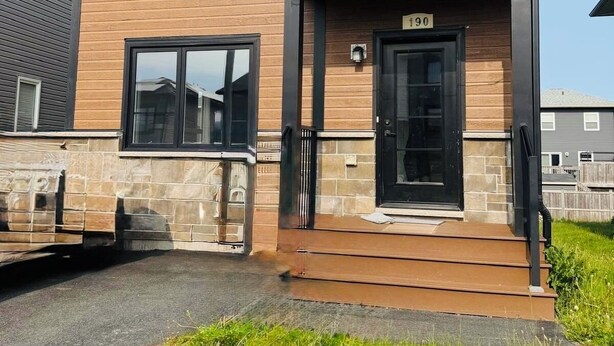 A two-story building with a stone facade, a black front door, and a number '190' above the entrance. - Cozy Private Basement Suite (Halifax)
