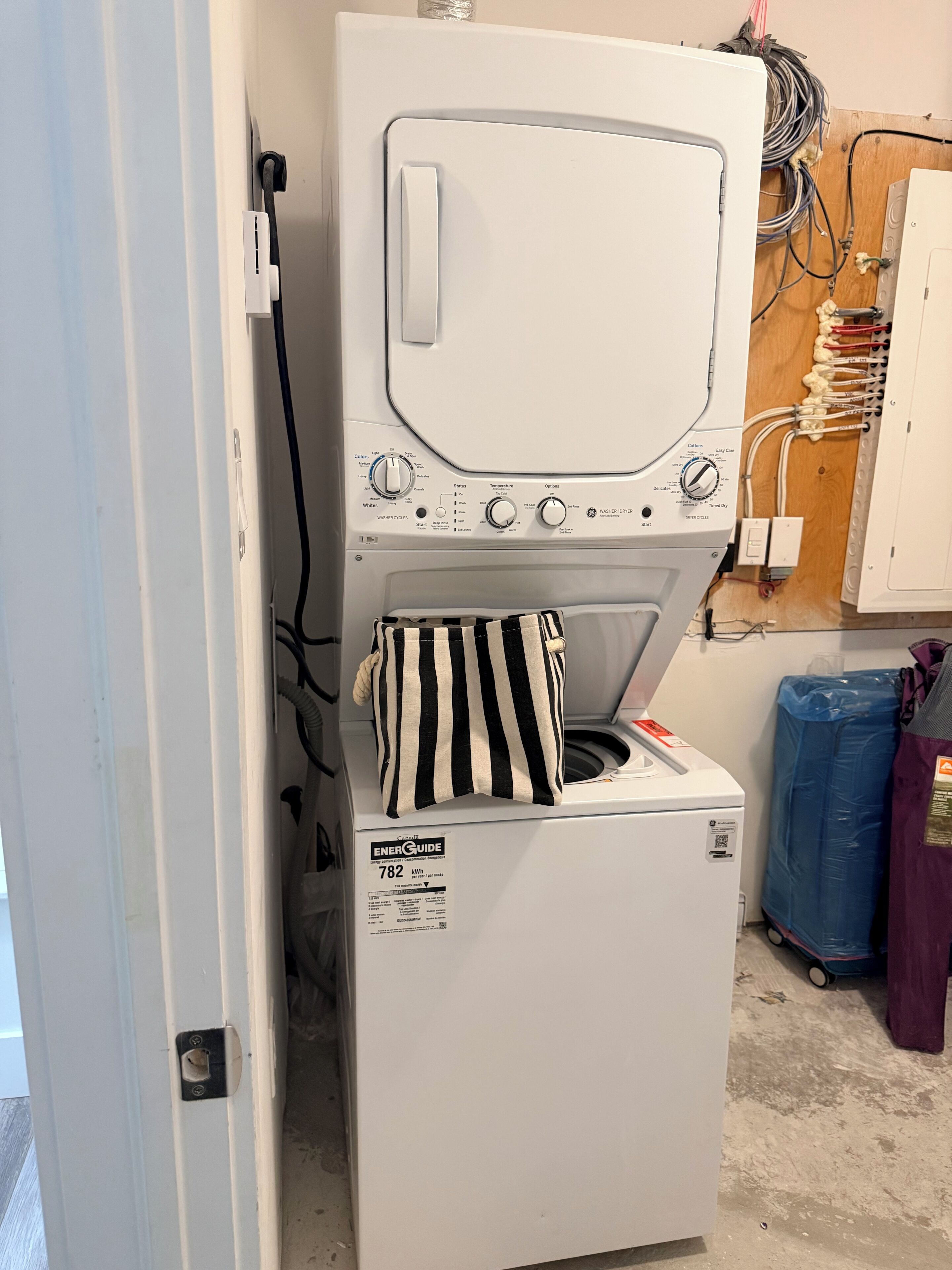 Eine Waschmaschine mit Frontlader, Bedienfeld, Netzkabel und einem Energielabel.