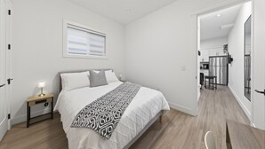 Ein Schlafzimmer mit Bett, Nachttisch und Fenster.