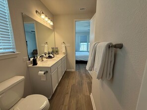Ein Badezimmer mit Toilette, Waschbecken, Spiegel und Handtuchhalter.