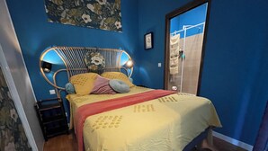 A bedroom with a bed, a headboard with lights, a floral wall decoration, and a window with curtains. - 2 p+balcony ideally located with splendid view of the Canal Royal and the port of Sète (Sète)