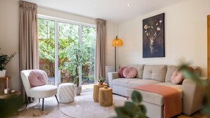 A modern living room with a sofa, armchair, and a small round table. - Luxury forest stay with covered terrace and BBQ (Hattemerbroek)