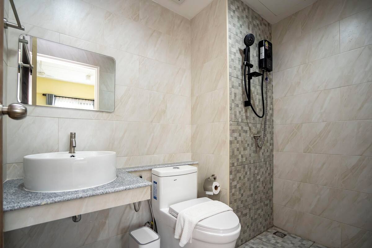 A bathroom with a sink, toilet, and shower.