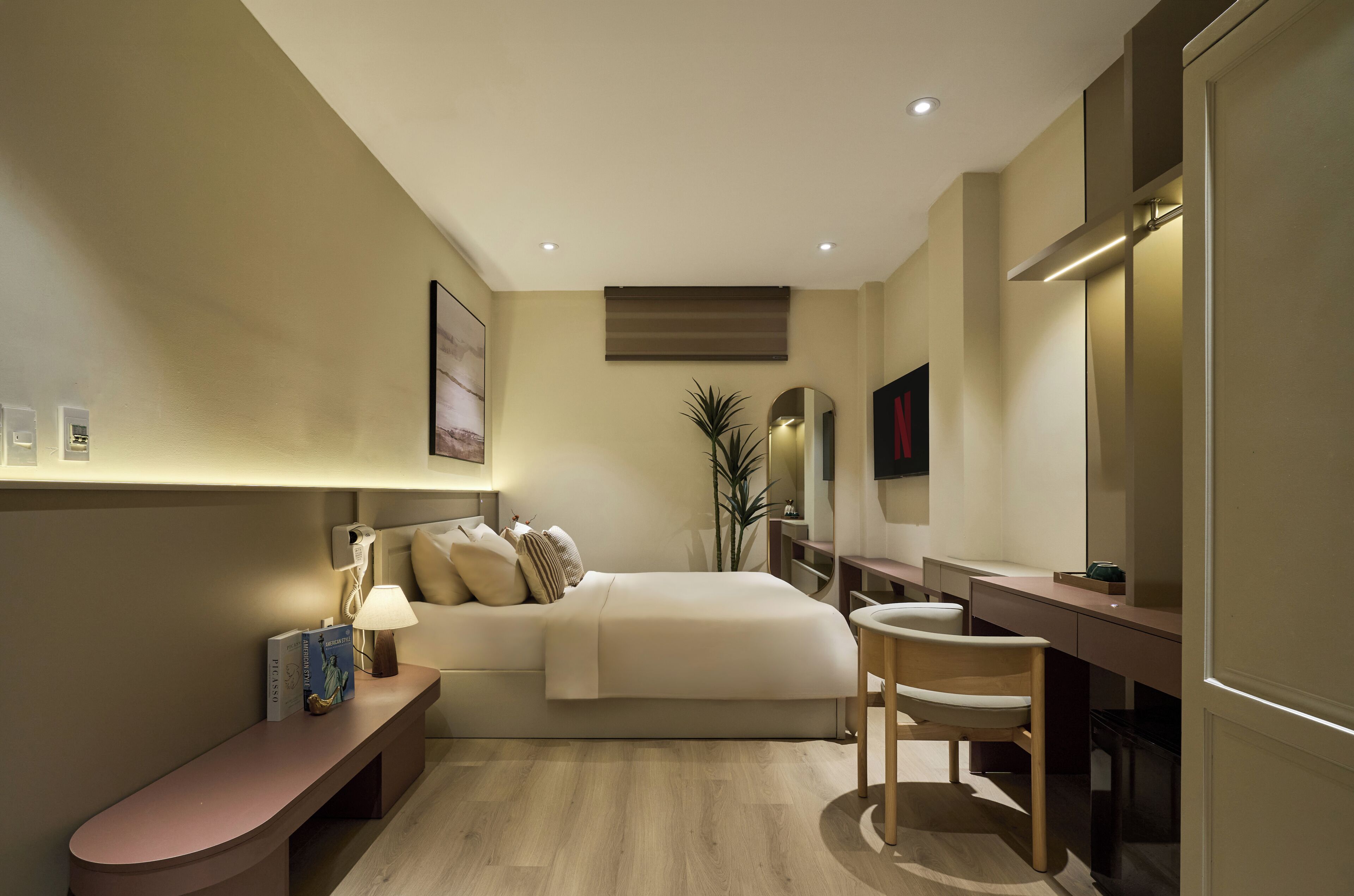 Une chambre moderne comprenant un lit, une table de chevet, une chaise et un bureau avec un miroir.