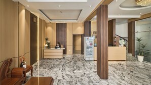 A hotel lobby with a reception desk, a vending machine, and a staircase leading to another floor. - Linh Dan Hotel Phan Xich Long By Urban B (Ho Chi Minh City)
