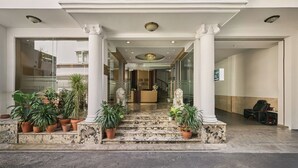 The entrance of Linh Dan Hotel with a grand staircase, columns, and potted plants. - Linh Dan Hotel Phan Xich Long By Urban B (Ho Chi Minh City)