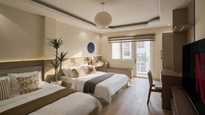 A hotel room with two beds, a TV, a desk, a potted plant, and a large window. - Linh Dan Hotel Phan Xich Long By Urban B (Ho Chi Minh City)