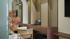 A modern bathroom with a mirror, a sink, a chair, and a small plant. - Linh Dan Hotel Phan Xich Long By Urban B (Ho Chi Minh City)