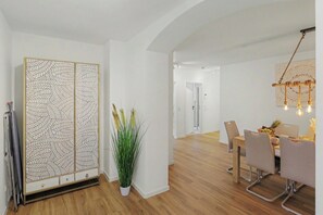 A modern interior with a dining area, a decorative plant, and a patterned cabinet. - Master’s Bridge: with garage & balcony near dyke (Bremerhaven)