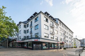 A multi-story building with a SWB sign, indicating a business or service on the ground floor. - Master’s Bridge: with garage & balcony near dyke (Bremerhaven)