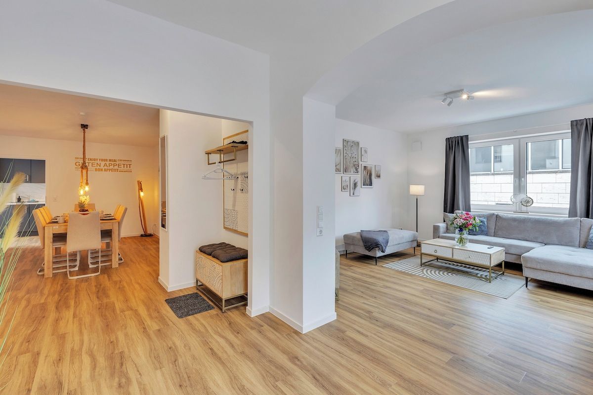 Un salon moderne avec un canapé, une table basse et des œuvres d’art accrochées au mur.