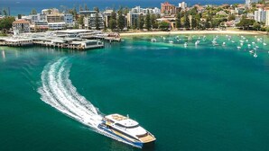 Un grand yacht navigue dans une marina, avec une vue sur la ville en arrière-plan.