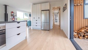 Eine moderne Küche mit weißen Schränken, einem Edelstahlkühlschrank und Holzboden.