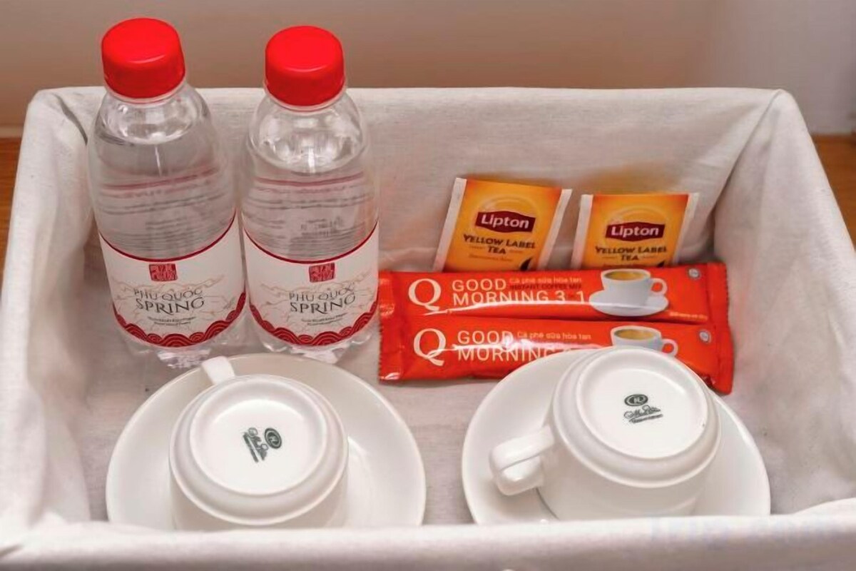 Un plateau avec deux bouteilles d’eau, deux sachets de thé Lipton, deux tasses et deux soucoupes.