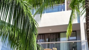 A modern building with a balcony and outdoor seating. - HANA HOTEL SONASEA NIGHT MARKET PHU QUOC (Phu Quoc)