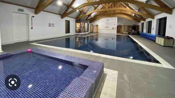 An indoor swimming pool with a tiled floor and wooden beams on the ceiling. - Charming Holiday Park Retreat in Morecambe - Family-Friendly Escape (Morecambe)