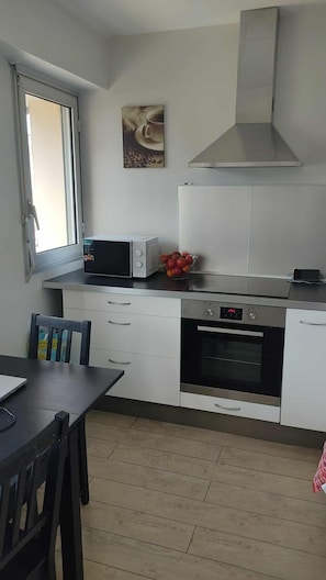 Eine moderne Küche mit Mikrowelle, Backofen und Fenster.