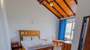 Un dormitorio con techo de madera, una cama, una mesita de noche, un banco y una ventana con cortinas.