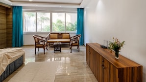 Un salon moderne comprenant un canapé, deux fauteuils, une table basse et un meuble en bois.