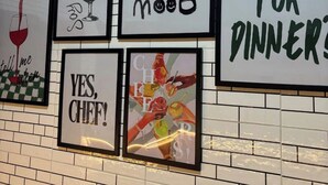 Eine Wand mit verschiedenen gerahmten Schildern zum Thema Essen und Gastronomie.