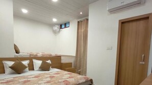 A bedroom with a bed, a wooden wardrobe, a ceiling fan, and an air conditioning unit. - Hotel Golden Oak Near Golden Temple (Amritsar)