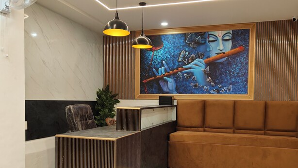A reception area with a marble floor, a reception desk, a sofa, pendant lights, and a wall mural. - Hotel Golden Oak Near Golden Temple (Amritsar)