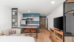 A modern hotel room with a kitchenette, a bed, a TV, and a dining area. - StudioRes by Marriott Memphis Cordova (Cordova)