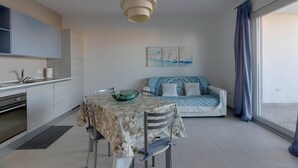 Een moderne keuken met een eethoek, een bank en een groot raam.