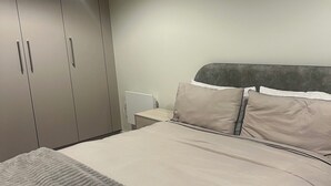 Ein Schlafzimmer mit einem Bett, einem Kleiderschrank und einem Nachttisch.