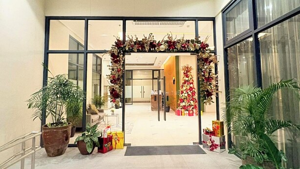 A spacious lobby with a large archway decorated with flowers and gifts, leading to a reception area.